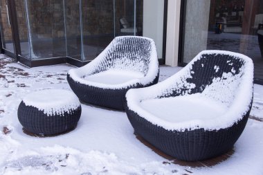 Snow covered chairs in garden clipart