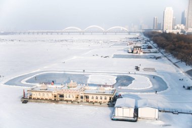 HARBIN, CHINA - JAN 18, 2017: People walking on the frozen Songhua River and There are many activities. January 18, 2017 in Harbin City, Heilongjiang, China. clipart