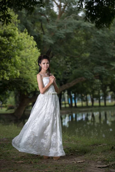 Азиатка в свадебном платье в лесу — стоковое фото