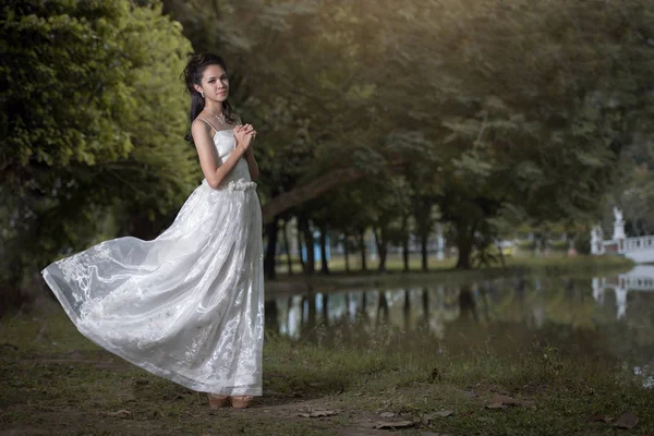 亚洲女孩穿着婚纱时在森林里 — 图库照片