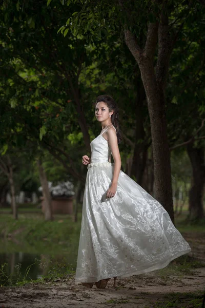 Азиатка в свадебном платье в лесу — стоковое фото