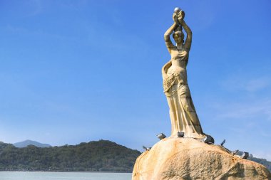 Zhuhai, Guangdong, Çin -Nis 16, 2017: Zhuhai Fisher kız heykeli 16 Nisan 2017 Xianglu coast koyunda bulunan Zhuhai şehir dönüm noktası vardır