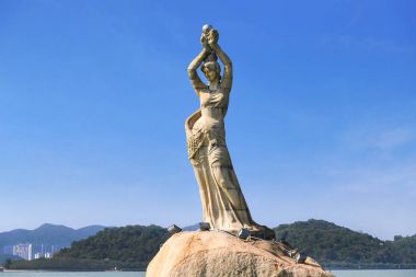 Zhuhai, Guangdong, Çin -Nis 16, 2017: Zhuhai Fisher kız heykeli 16 Nisan 2017 Xianglu coast koyunda bulunan Zhuhai şehir dönüm noktası vardır