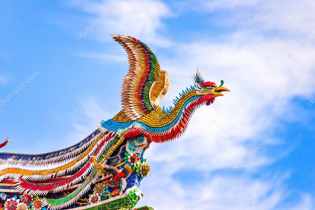 Beautiful Phoenix flying on the decorative tile roof in Chinese temples. Colorful roof detail of traditional Chinese temple