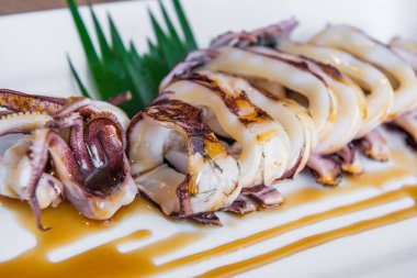 Beyaz tabakta soslu ızgara kalamar