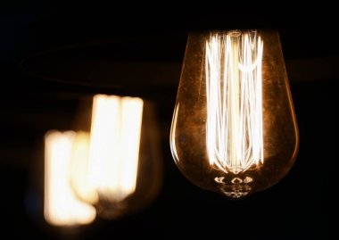 Parlak sarı parlayan ile koyu arka plan üzerinde Vintage ampul 