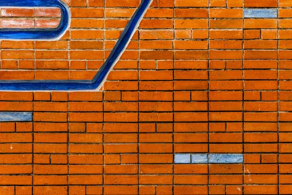 Mavi elementli kırmızı tuğla duvar.