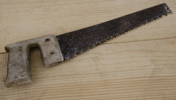 Eski marangozluk testeresi tahtanın arka planında.