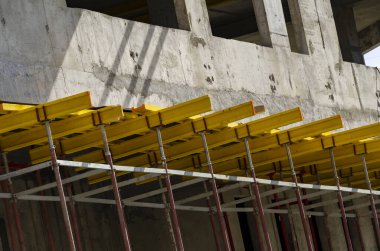 Monolitik beton bina inşaatı sırasında sarı inşaat ekipmanları.