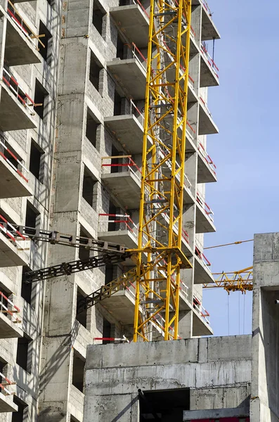 İnşaat halindeki tuğla bina ve inşaat kulesi vinci..