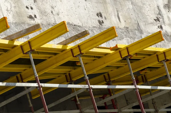 Sarı inşaat ekipmanları ve beton bina.