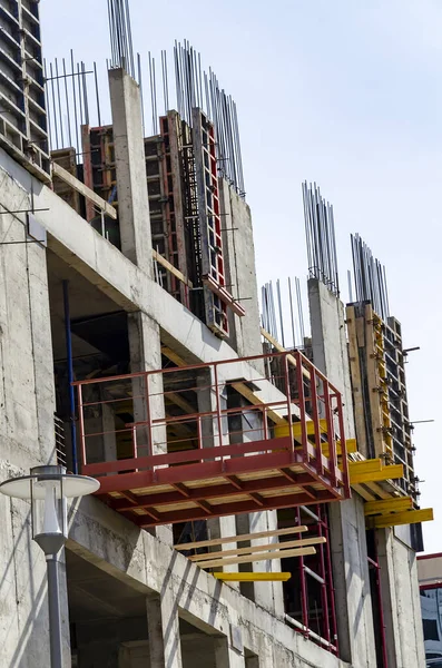 İnşaat halindeki beton bina, çelik takviye ve çit.