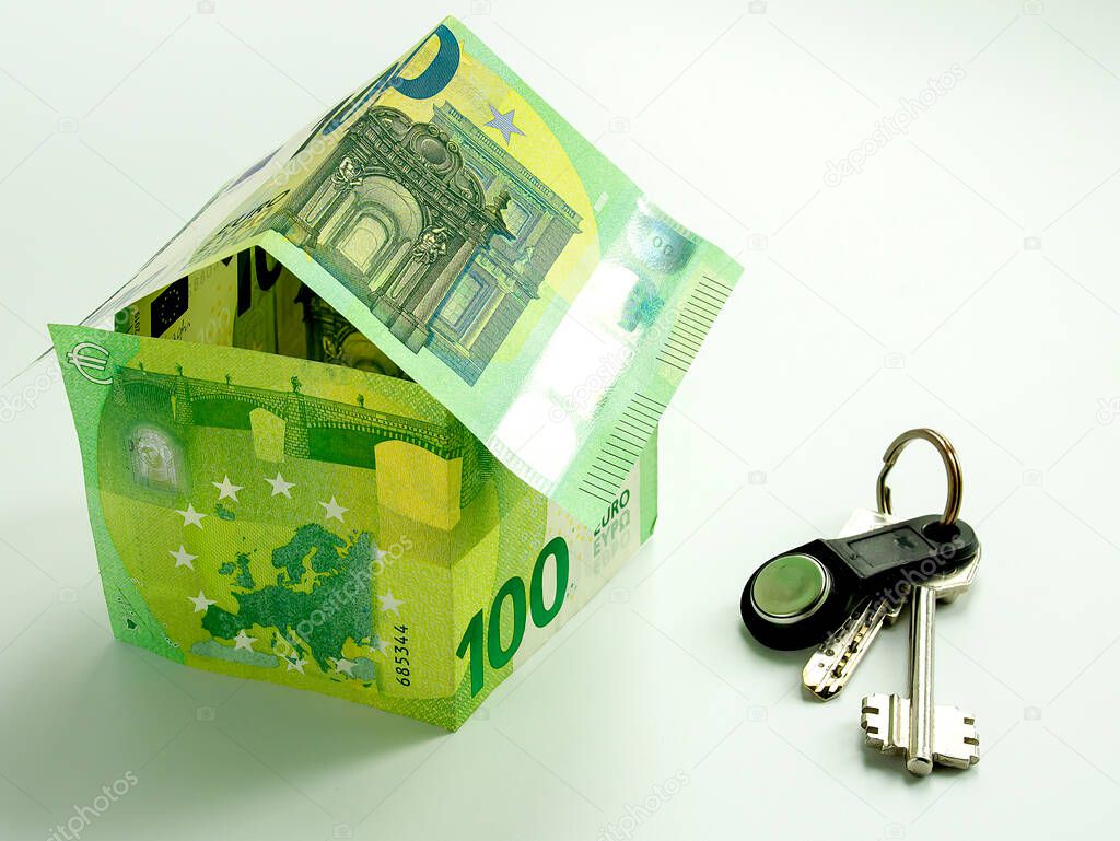 Banknotes of 100 euros, folded in the form of a house and house keys.
