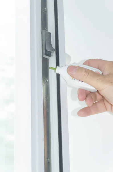 Yağlı bir el, pencere çerçevesini yağlar. Dikey