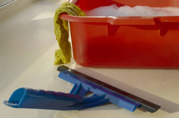 Cam temizleme seti: kırmızı leğen, sabunlu su, sarı bez, kırmızı sünger ve mavi plastik pencere temizleyicisi 1