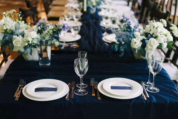 La decoración de la mesa de boda en las tarjetas de color azul oscuro con los nombres de las flores frescas — Foto de Stock