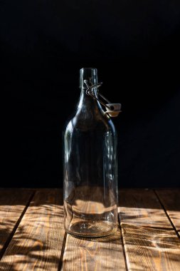 şeffaf cam şişe, kahverengi ahşap masa, arka plan, yakın plan, güneş ışığı, kontrastı şarap, süt, limonata.