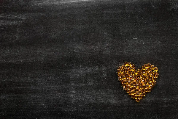Χούφτα Κίτρινα Χάπια Σχήμα Καρδιάς Μαύρο Φόντο Βιταμίνες Φροντίδα Λάδι — Φωτογραφία Αρχείου