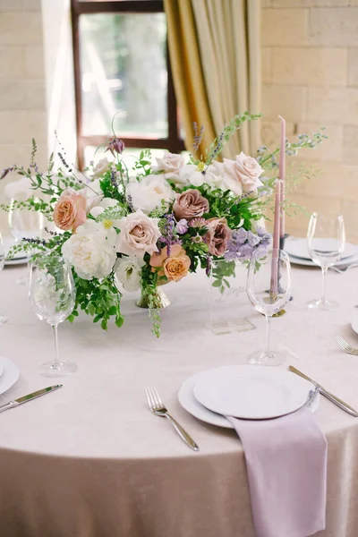 Asztalbeállítás egy luxus esküvő és gyönyörű virágok az asztalon. — Stock Fotó