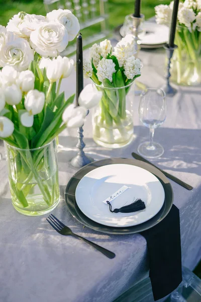 Asztalbeállítás egy luxus esküvő és gyönyörű virágok az asztalon. fekete-fehér — Stock Fotó