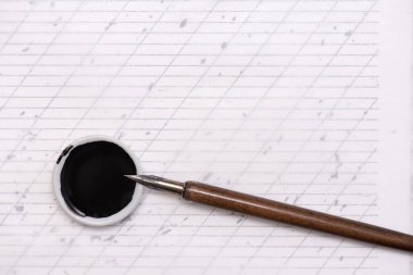 Kaligrafi kağıtları, kalem uçları, kağıt, tahta arka planda mürekkep. boş defter. Üst görünüm, düz uzanma.
