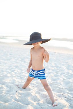 Kumun üzerinde duran küçük bir çocuk. 