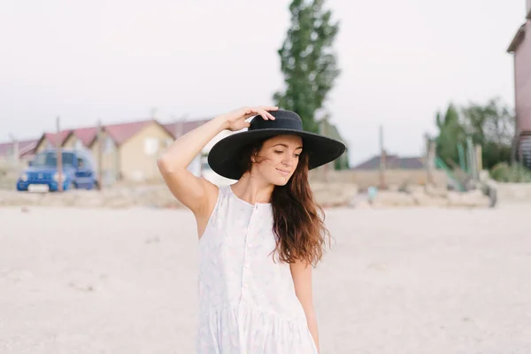 帽子を被った少女が海岸を歩き — ストック写真