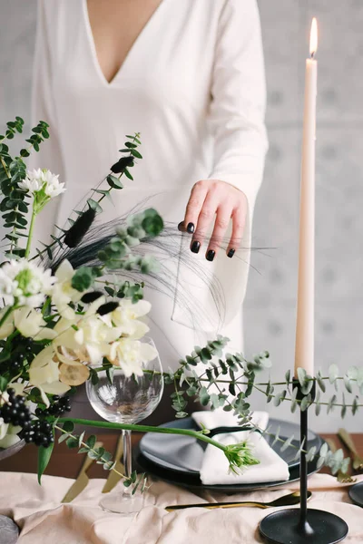 girls hand touches flowers. Table setting at a luxury wedding and Beautiful flowers in a vase on the table.
