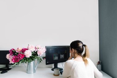 Bahçe sulama kutusunda şakayıklar, evde bir masaüstü. İşteki kadın