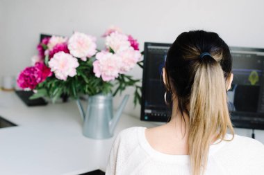 Bahçe sulama kutusunda şakayıklar, evde bir masaüstü. İşteki kadın