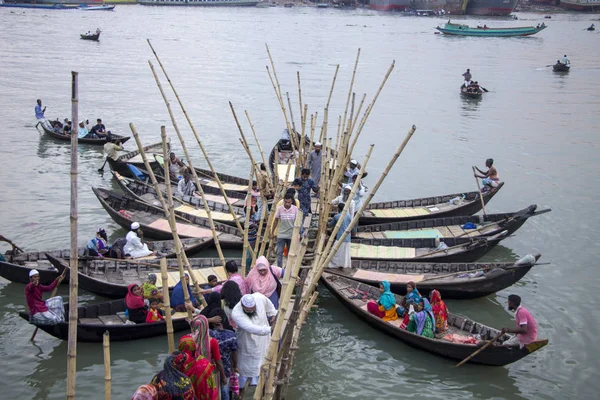 İnsanlar Sadarghat dhaka Bangladeş 'ten geçmek için Turag Nehri' ndeki tekne standında ahşap tekneye binip iniyorlar ve tekne limanından çıkıyorlar.
