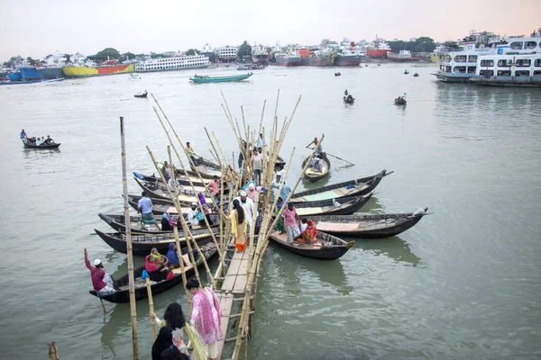 İnsanlar Sadarghat dhaka Bangladeş 'ten geçmek için Turag Nehri' ndeki tekne standında ahşap tekneye binip iniyorlar ve tekne limanından çıkıyorlar.