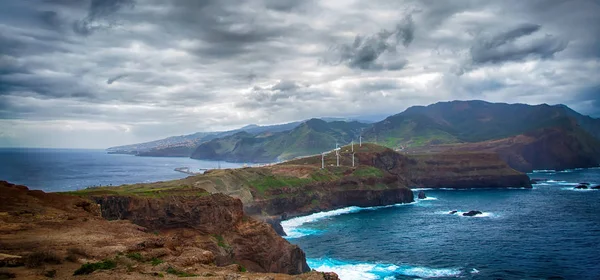 Mavi okyanus, dağlar, kayalar, yel değirmenleri ve Portekiz bulutlu gökyüzü