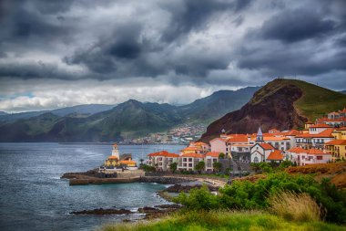 Bir küçük kasaba whith okyanus ve dağ deniz feneri. Portekiz, Madeira Adası, Canical