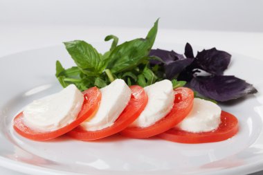 Caprese Mozzarella peyniri domates fesleğen mavi, yeşil, yakın çekim izole