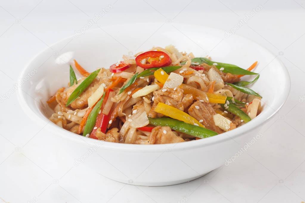 wok noodles with beef vegetables, ginger, sweet pepper on a plate isolated