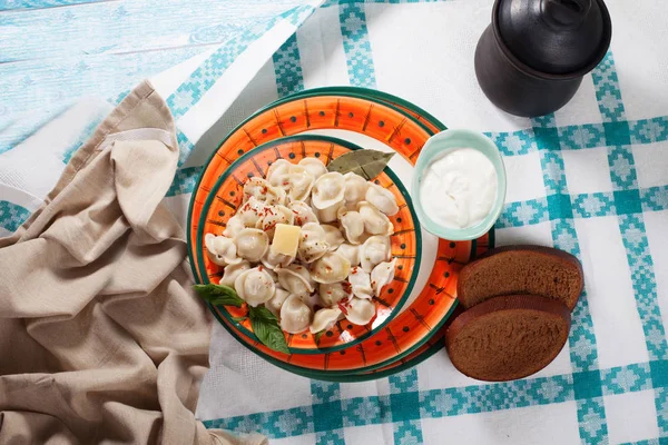 Dumplings på plattan ljusa aptitlig, smör, lagerblad, ovanifrån, stilleben, hem kök, bordsskiva med en rutig duk — Stockfoto