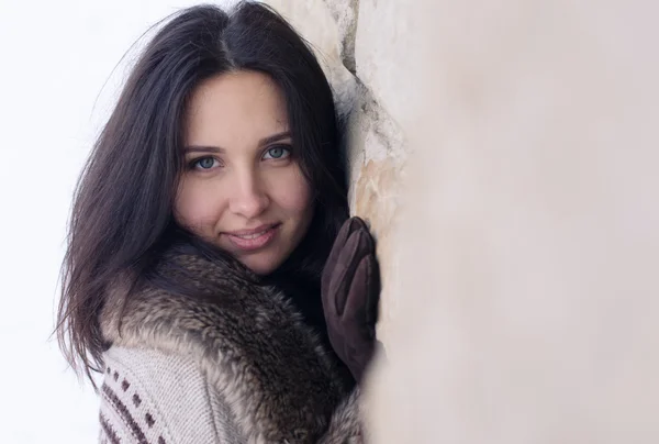 Ritratto di una bella ragazza vicino al muro in inverno — Foto Stock