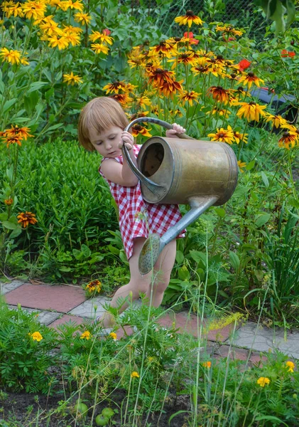 Κοριτσάκι βοηθά να ποτιστούν τα λουλούδια — Φωτογραφία Αρχείου
