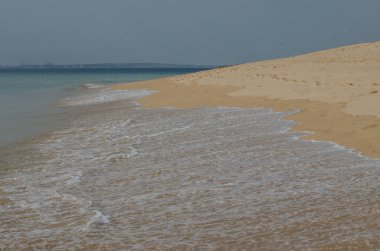 Kum okyanus kıyıya yakın yerde Porto Covo, Portekiz için acele dalgalar.