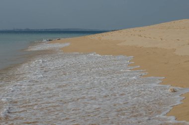 Kum okyanus kıyıya yakın yerde Porto Covo, Portekiz için acele dalgalar.