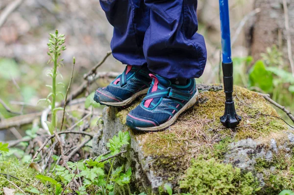 Childs voeten staan op een rotsachtige hoogteweg — Stockfoto