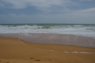 Kum okyanus kıyıya yakın yerde Lagos, Portekiz için acele dalgalar