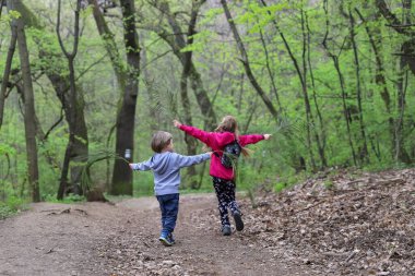 Oğlan ve kız baharın başında ormanda uçarak oynuyorlar.