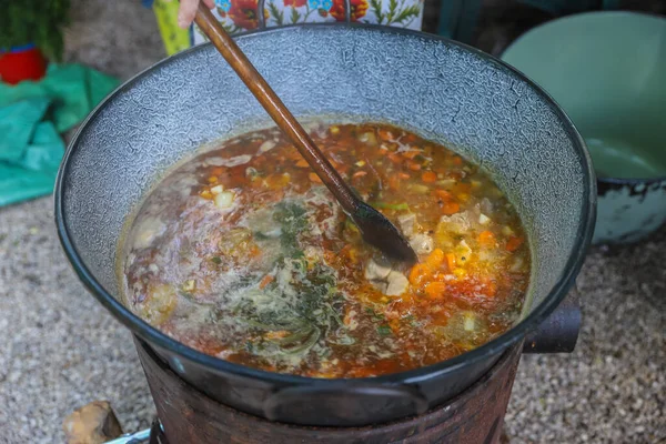 Borsch in a huge cauldron - traditional beetroot soup on the picnic — Stock Photo, Image