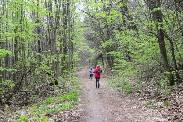 Erkek ve kız baharın başında ormanda koşuyor ya da yürüyüşe çıkıyorlar.