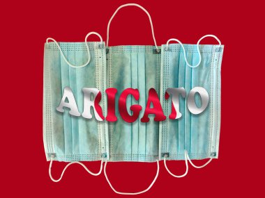 Palabra gracias en japones sober textura de mascarillas weltoras de papel antivirus on color rojo y blanco. Aplauso a las personas que luchan contra la pandemia del Covid-19. Agradecimiento en idioma japons ayık fondo de la bandera de Japn.