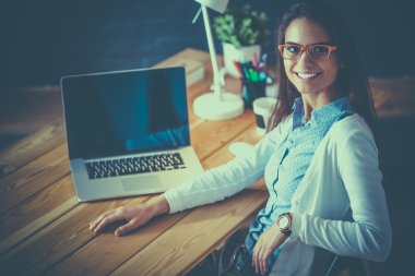 Masada oturan genç bir kadın.