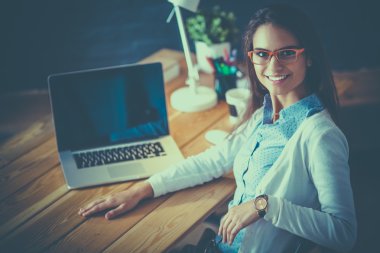 Masada oturan genç bir kadın.
