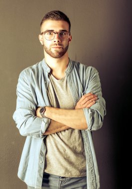Mutlu bir casual adam ayakta karanlık bir arka plan üzerinde izole portresi